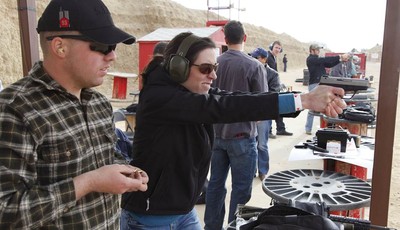 
              In this Dec. 22, 2012 photo, three weeks back home from the war in Afghanistan, U.S. Army 1st Lt. Aaron Dunn, center, instructs his wife Leanne in effective hand gun operation, at Drago